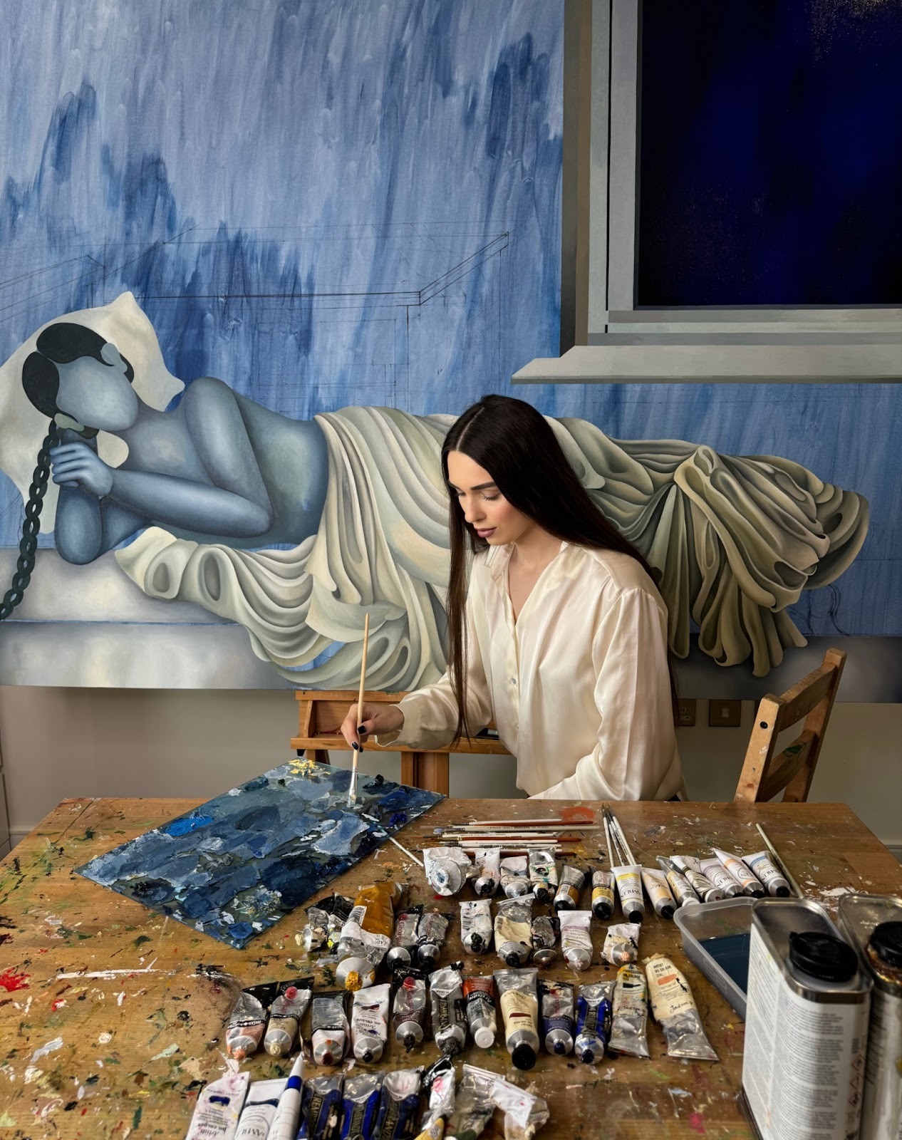Young female artist Celine Ali, one of the best emerging artists to invest in, paints in her London studio